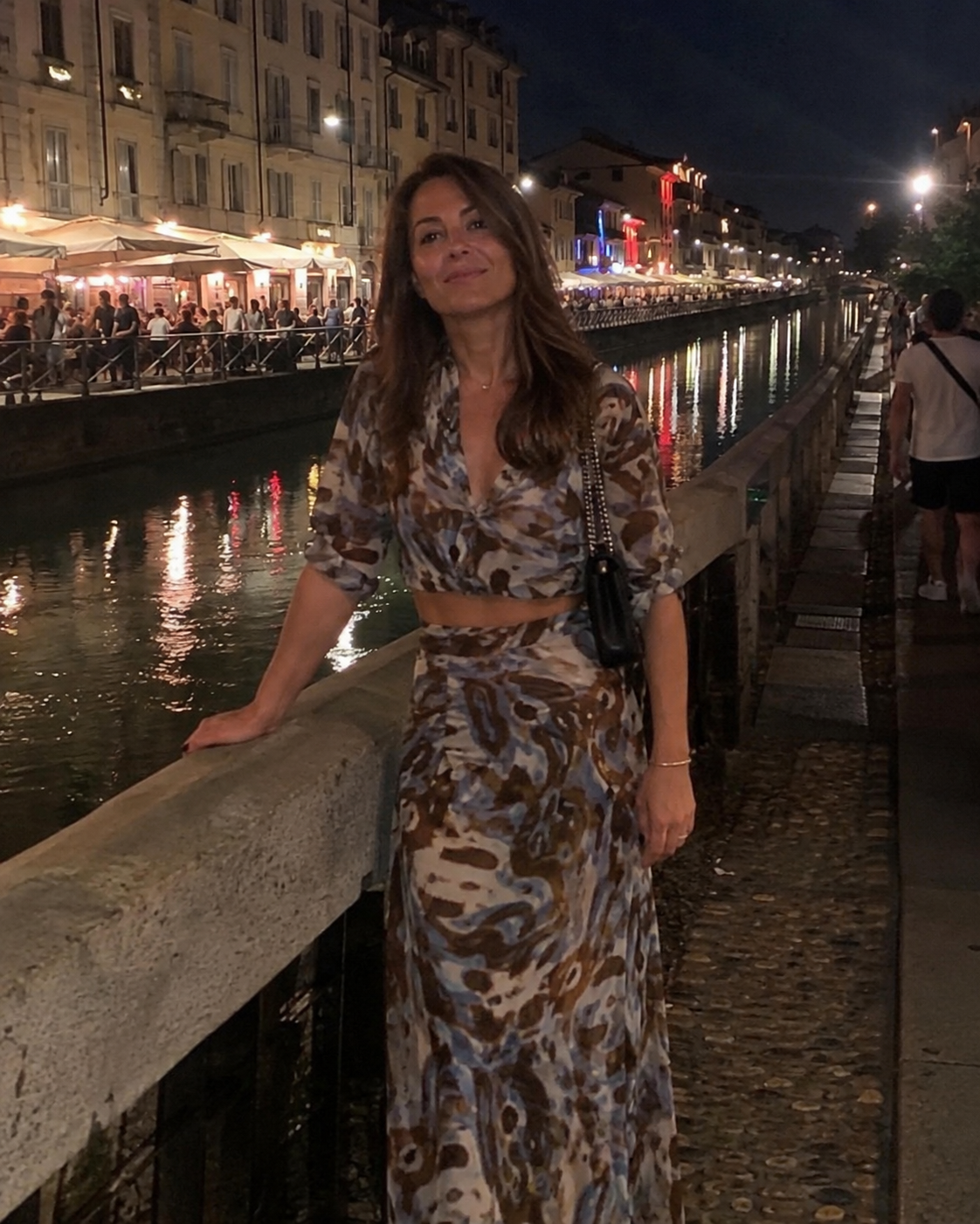 Donna di circa 40 anni con completo camicia corta e gonna lunga ai Navigli di Milano di notte