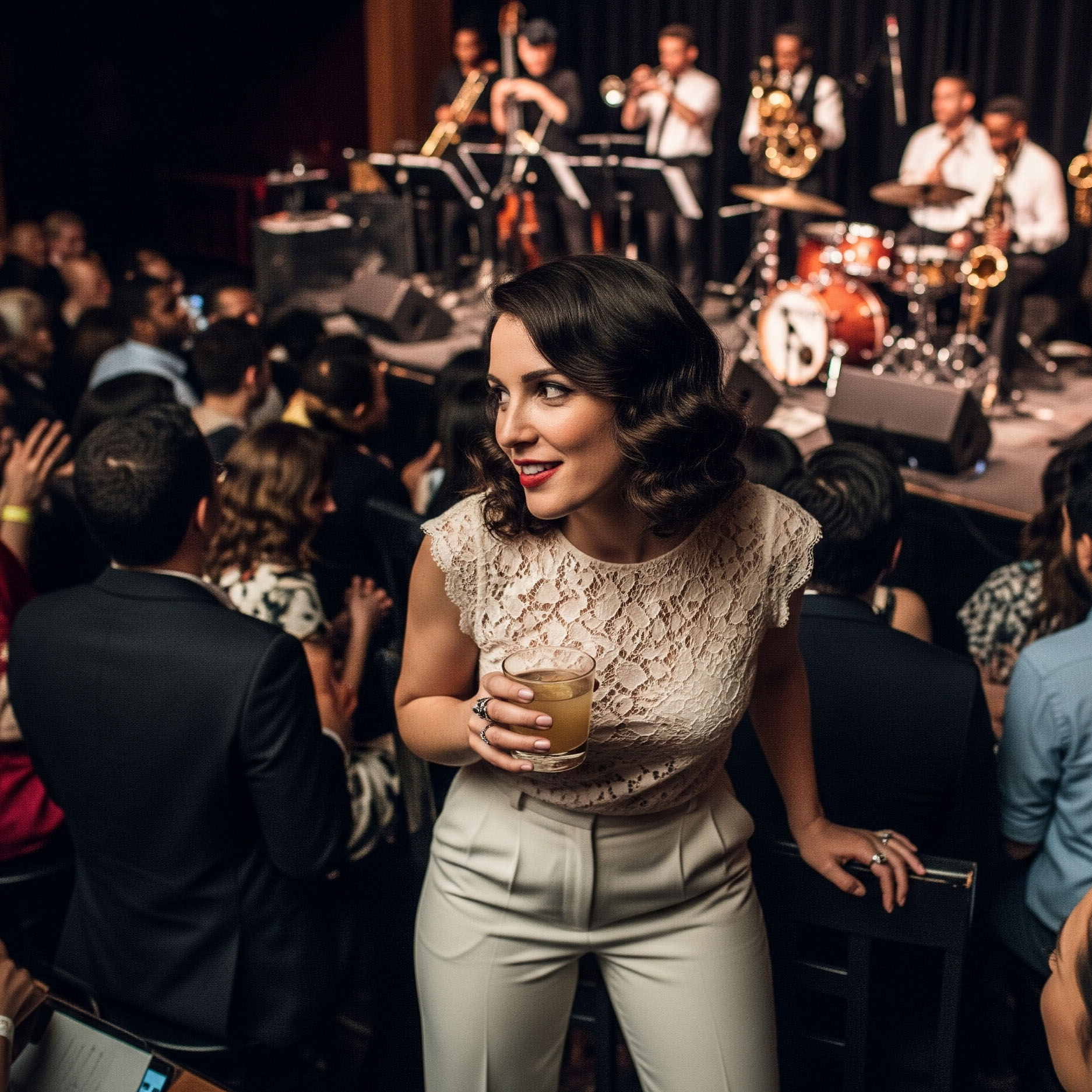 Donna con acconciatura vintage indossa un look da concerto jazz: pantaloni a sigaretta chiari e un romantico top in pizzo color crema.