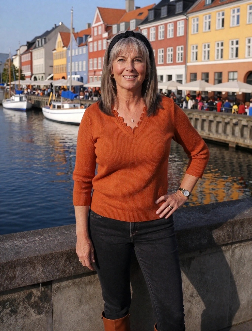 Outfit autunnale a Copenaghen con maglione color ruggine, jeans neri e stivali marroni a Nyhavn