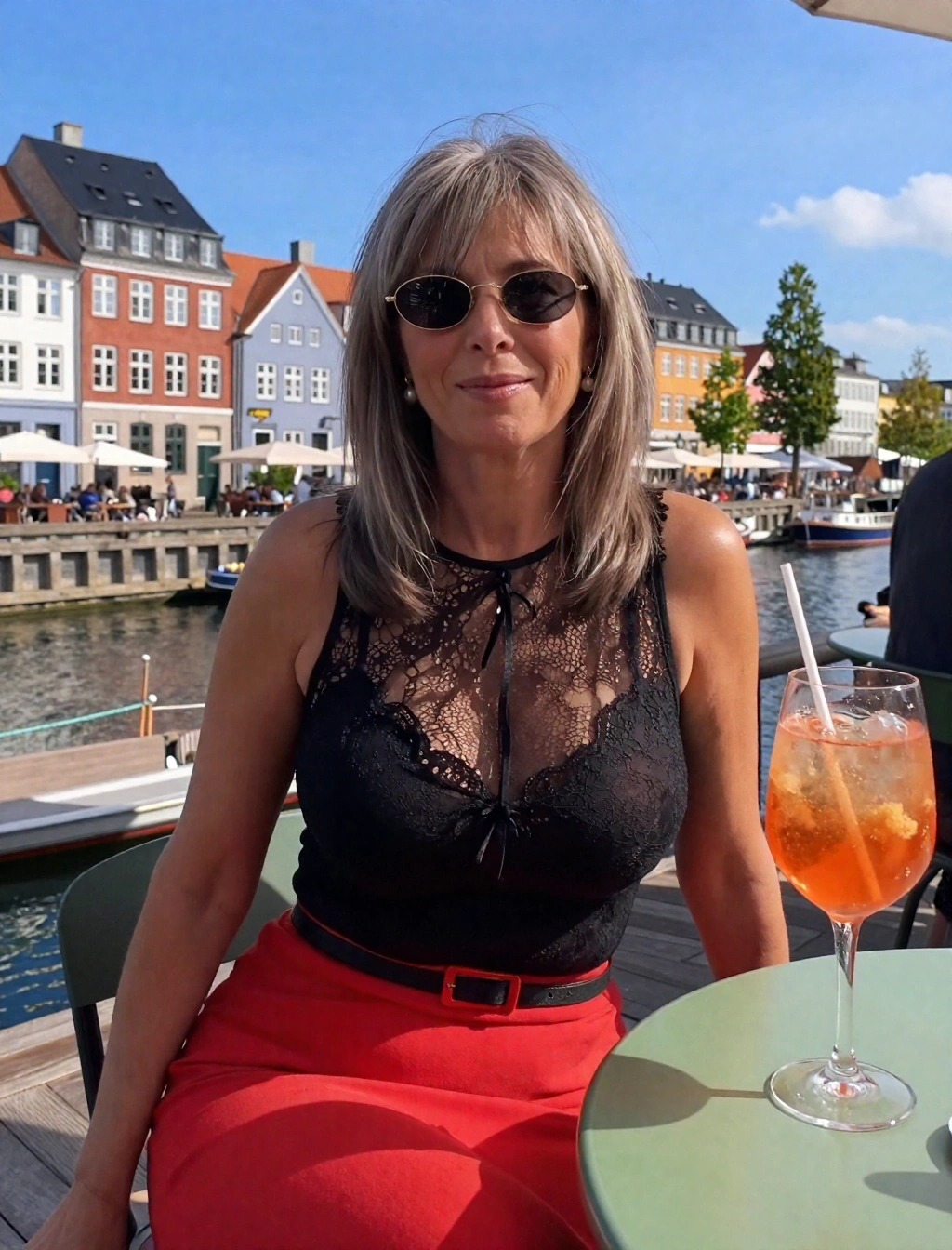 Donna con top in pizzo nero e gonna rossa a Nyhavn, Copenaghen, outfit estivo per aperitivo