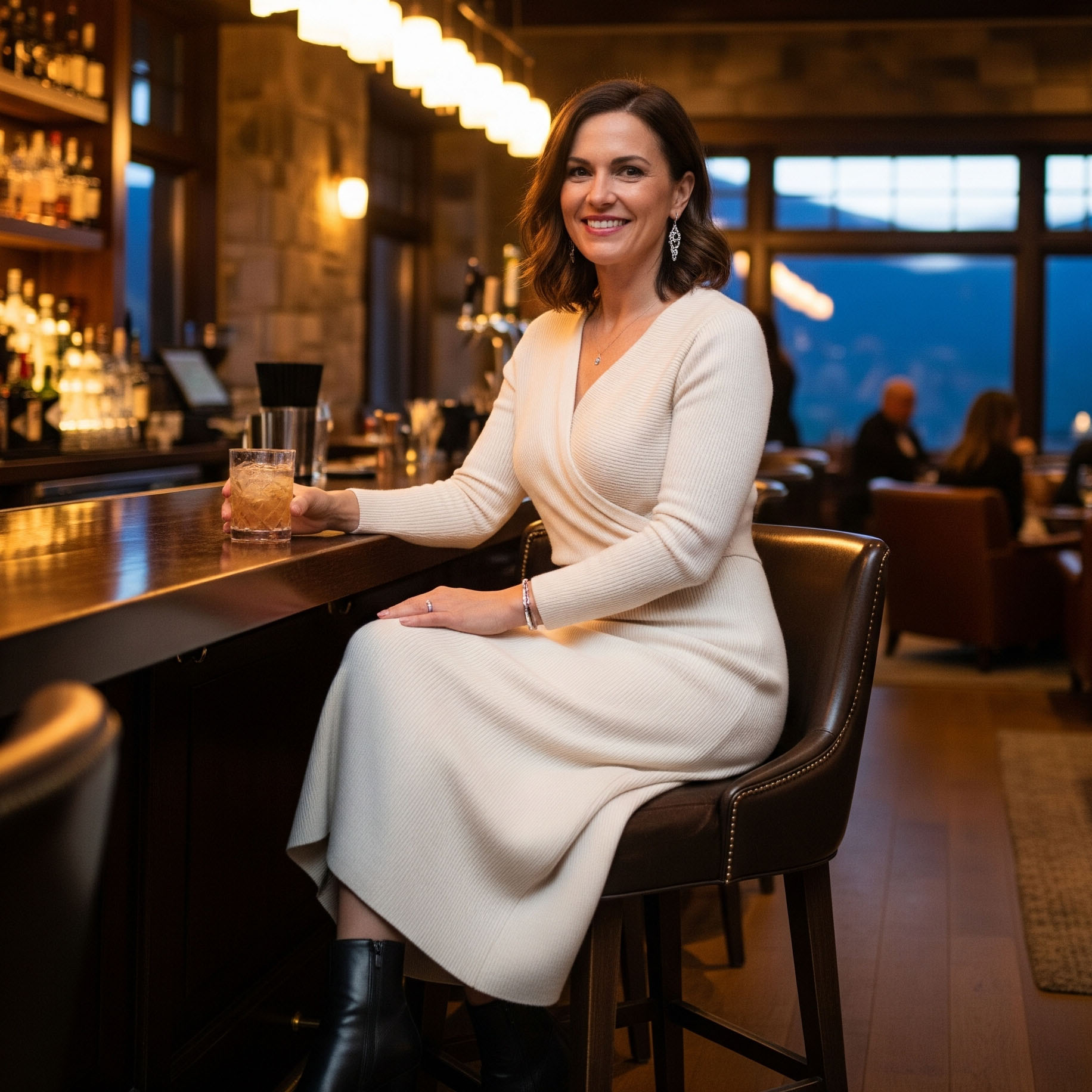 Come Vestirsi la Sera in Montagna d'estate: Guida per Donna 25 Donna con abito in maglia elegante e stivaletti in un lounge bar di lusso in montagna di sera, per un look da serata speciale.