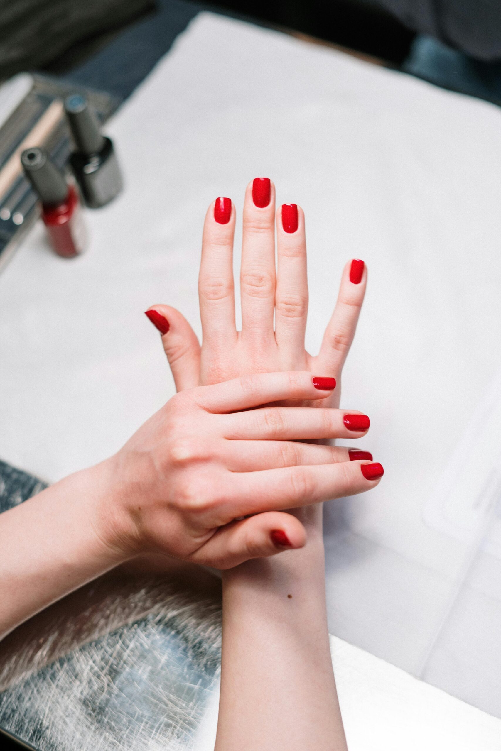 7 colori di smalto che stanno bene su tutto da Provare Ora 10 Manicure professionale con smalto rosso su unghie corte, trattamento estetico in salone con estetista che cura le mani.