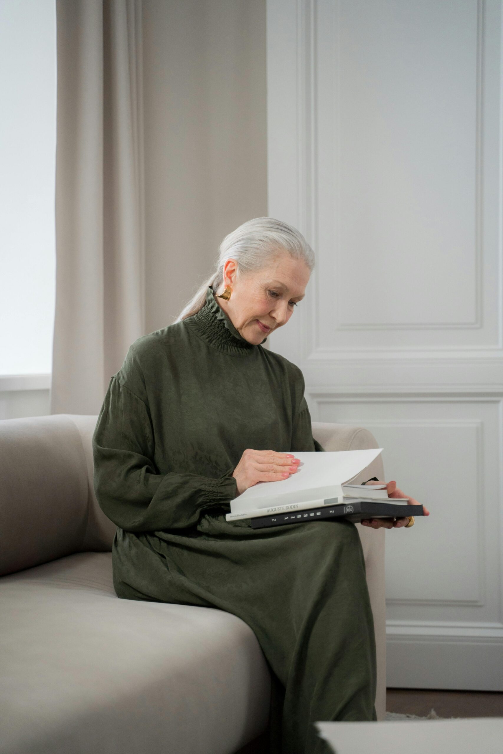 donna di 70 anni che legge sul divano per stare bene e rilassarsi