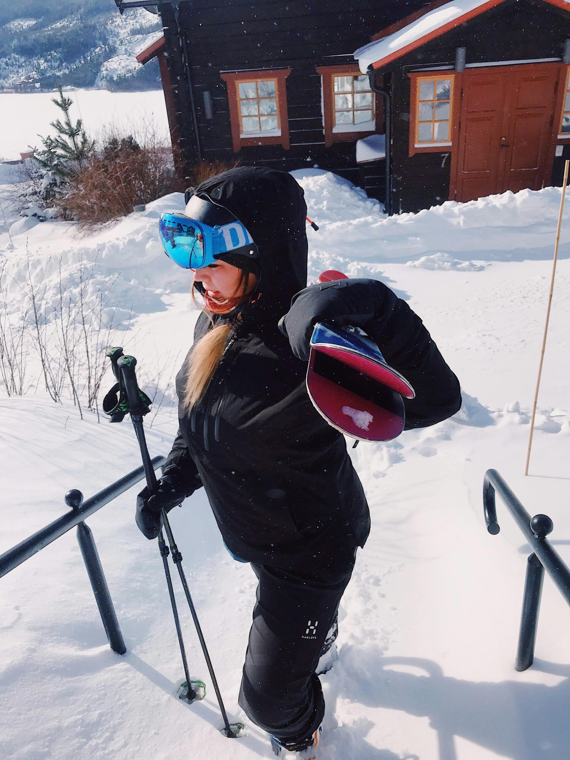 Donna con completo da sci nero, giacca e pantaloni tecnici come terzo strato per sciare