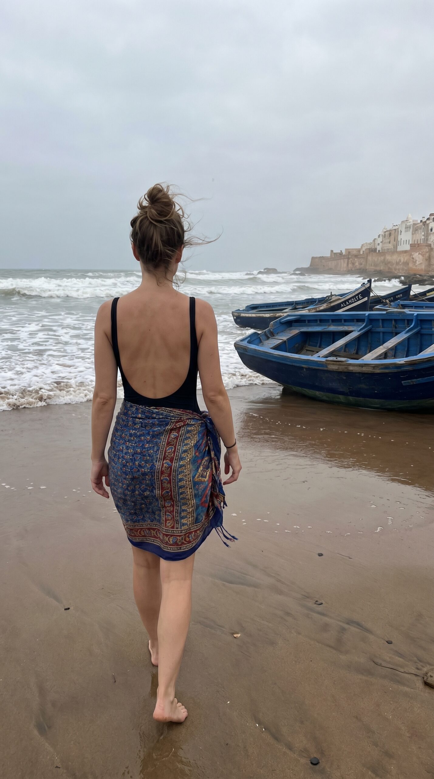 Donna in costume con pareo a Essaouira, abbigliamento da spiaggia consentito in Marocco

