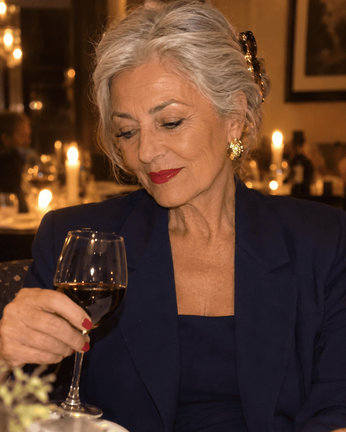 Come Vestirsi a 70 Anni: Guida Completa e Consigli Pratici 18 Donna di 70 anni con tailleur blu notte e orecchini dorati per un'occasione elegante