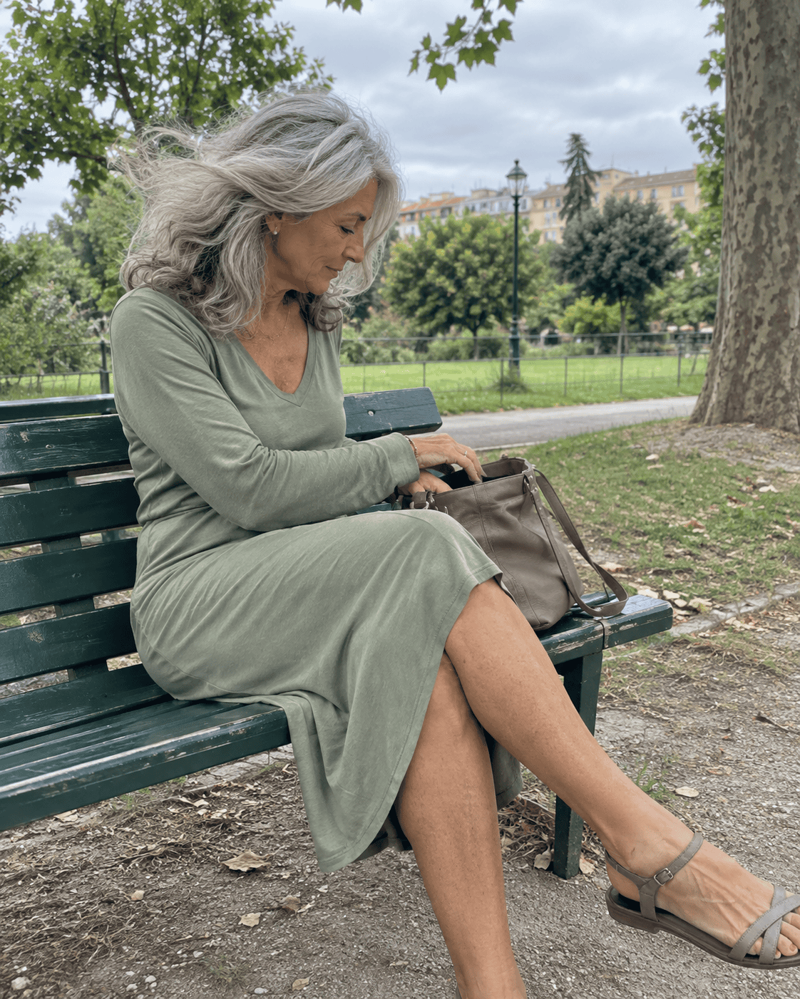 Come Vestirsi a 70 Anni: Guida Completa e Consigli Pratici 14 Donna di 70 anni con vestito in jersey verde salvia seduta su una panchina in un parco