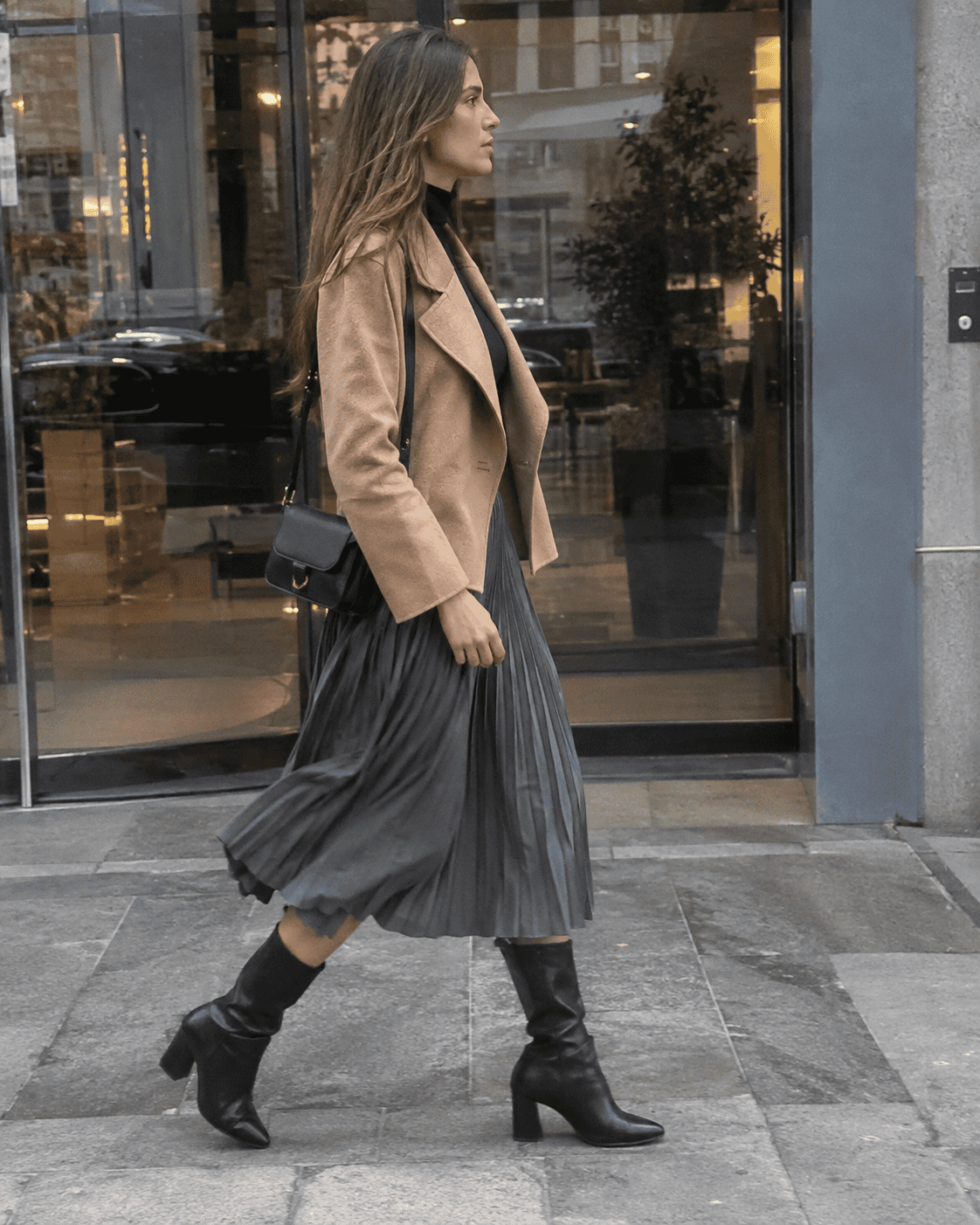 Outfit ufficio 12 gradi: gonna midi plissé grigia, dolcevita nero, cappotto corto cammello e stivali al polpaccio