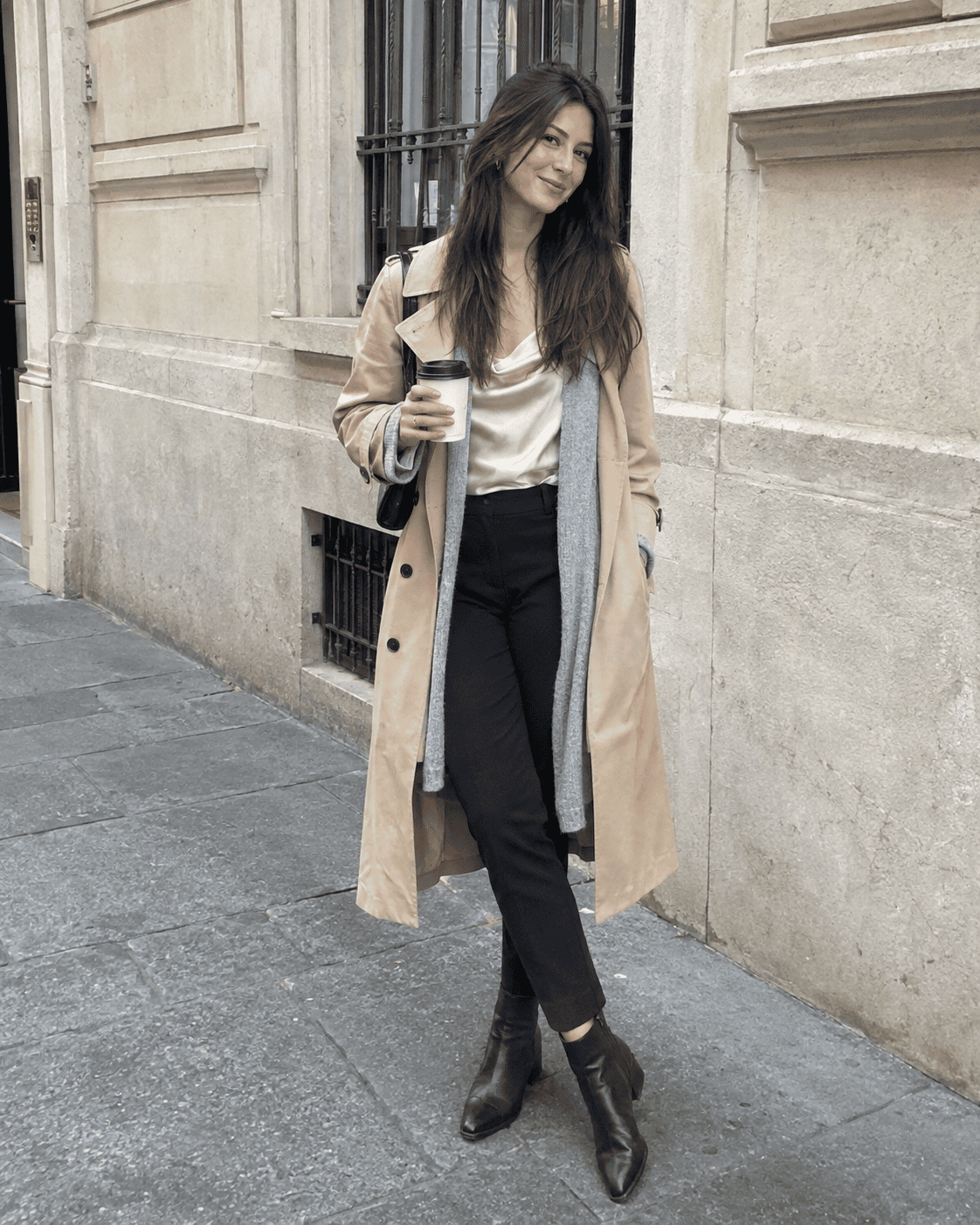 Outfit ufficio 12 gradi: pantaloni a sigaretta neri, top in seta champagne, cardigan grigio, trench beige e stivaletti