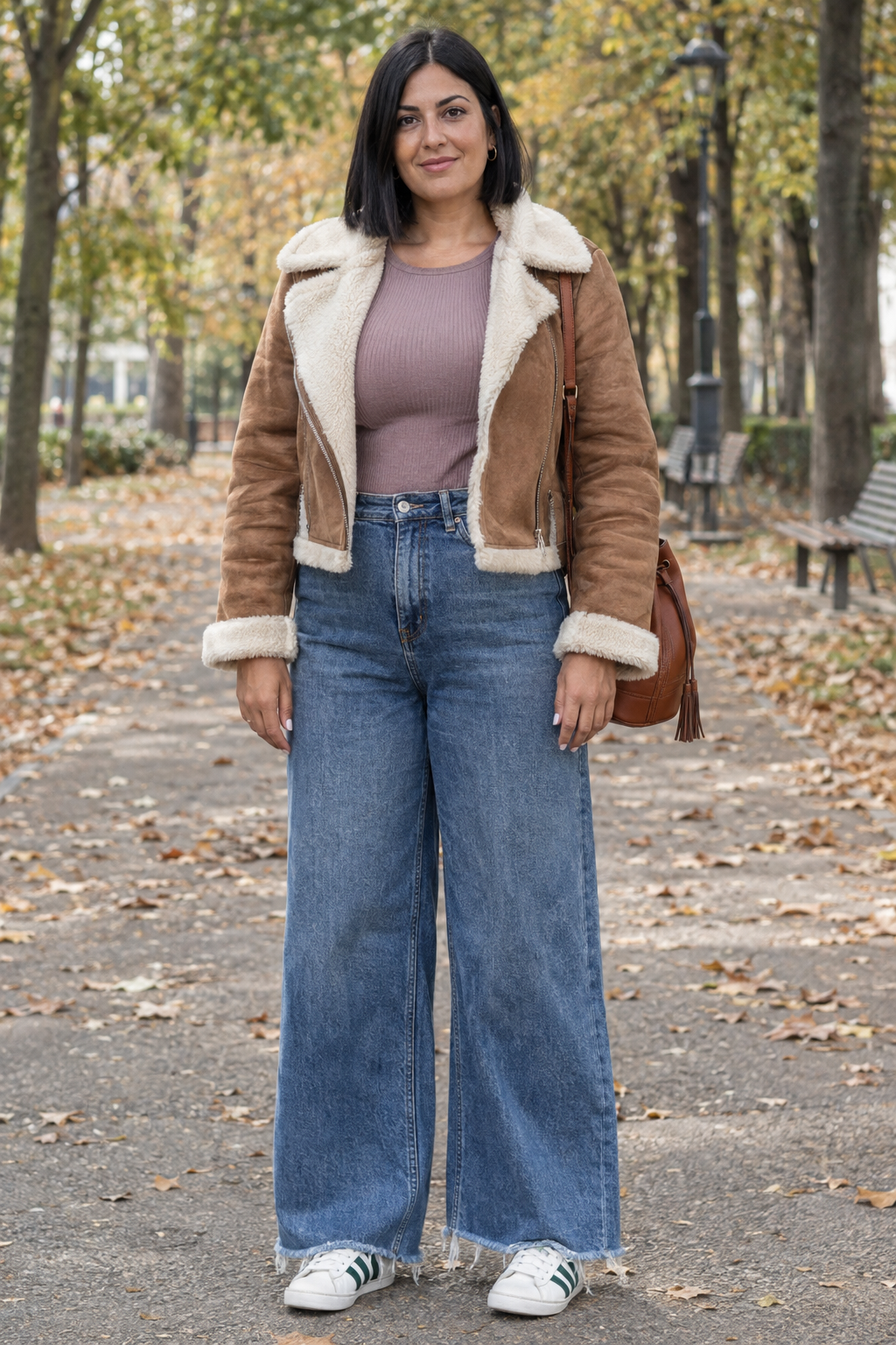 donna con outfit autunnale chic e comodo, giubbotto shearling marrone, top malva e jeans a gamba larga con sneakers bianche